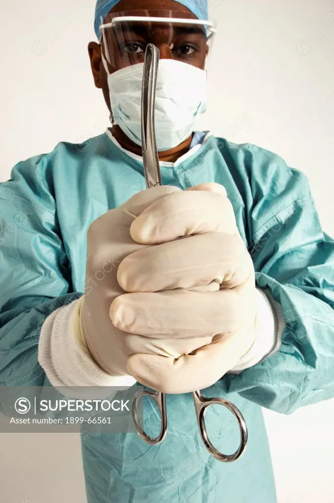 Portrait of surgeon holding pair of forceps in his