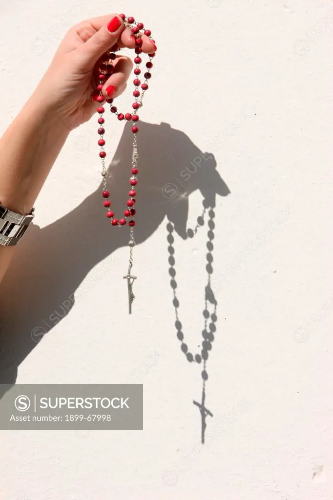 Woman praying with a prayer beads.