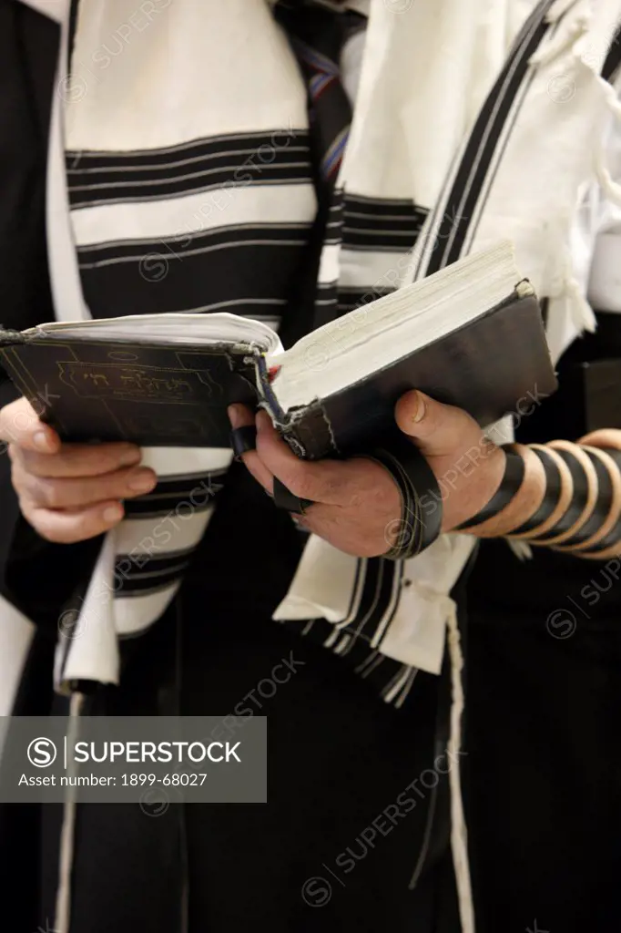 Orthodox Jew holding a prayer book and wearing a taleth (prayer shawl)