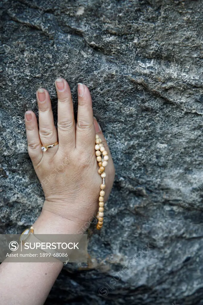 Pilgrim touching the Lourdes grotto