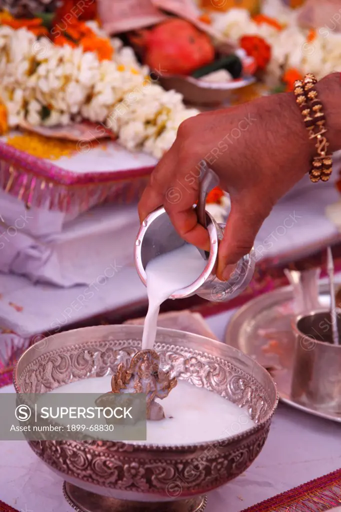 Puja in a Hindu temple : bathing of a statue of goddess Durga with milk