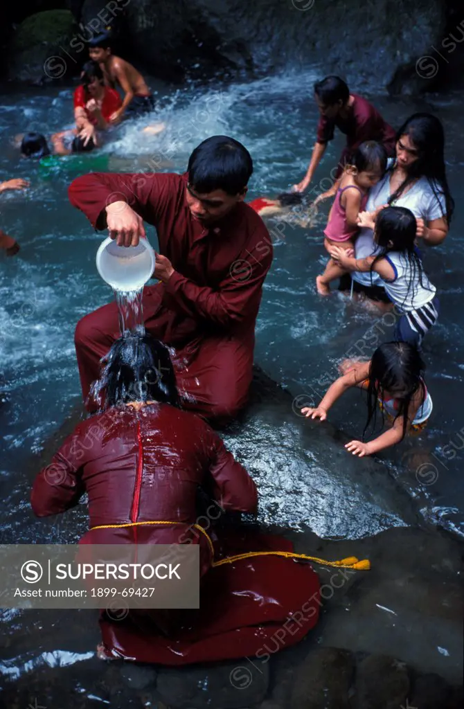 Filipino pilgrim bathing in Santa Lucia holy water at the foot of Mount Banahaw during Lent
