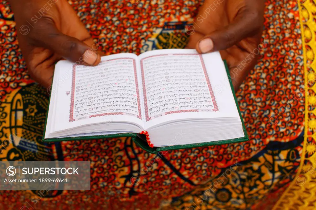 African woman reading the Koran.