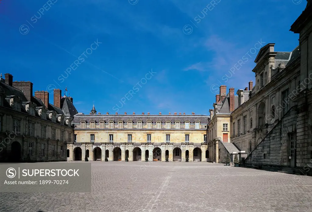 France, Fontainebleau, Palace of Fontainebleau. Detail. Fontainebleau 'cour de la Fontaine' court and 'aile Charles IX' side wing. Facade of the 'galerie Francois I' and paving surface in the foreground.