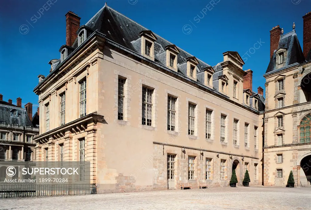 France, Fontainebleau, Palace of Fontainebleau. Detail. Angular foreshortening external Fountainebleau Palace 'cour de la Fontaine' court. Wing, made with ashlar technique, with windows. Roof with chimneypots and slopes.