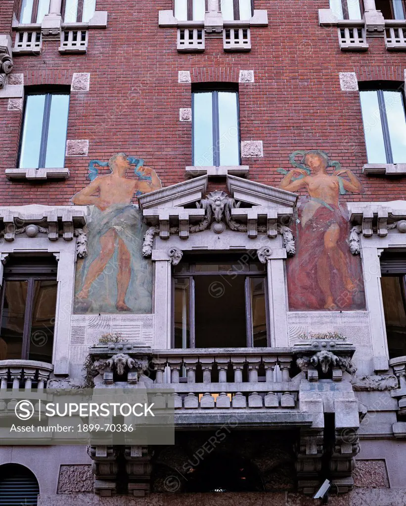 Italy, Lombardy, Milan, Mozart street 21. Detail. View of the facade, with a balcony, a tympanum and a mural painting depicting a man and a woman.