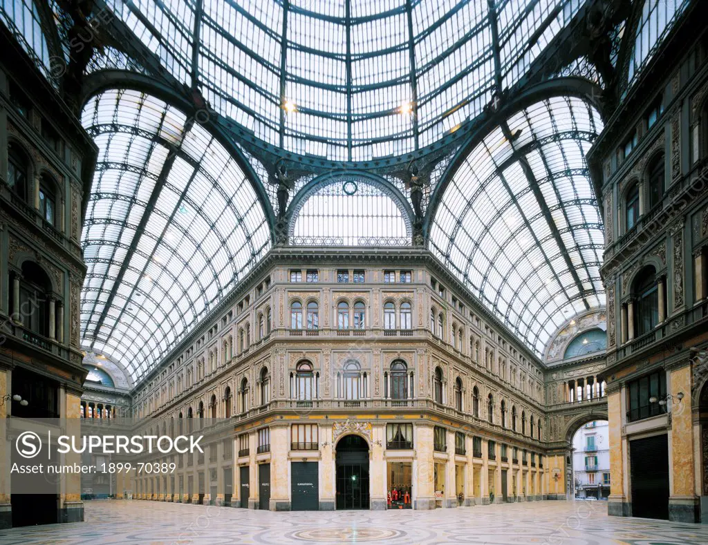 Italy, Campania, Naples, Galleria Umberto I. Detail on the interior of the Galleria Umberto I, with cover o iron and glass. Facades of palaces and superimposed orders. At the sides of the wondows are small pillars. The arches are complete of biforas and single-light windows. The meeting of the arms creates a cupola.