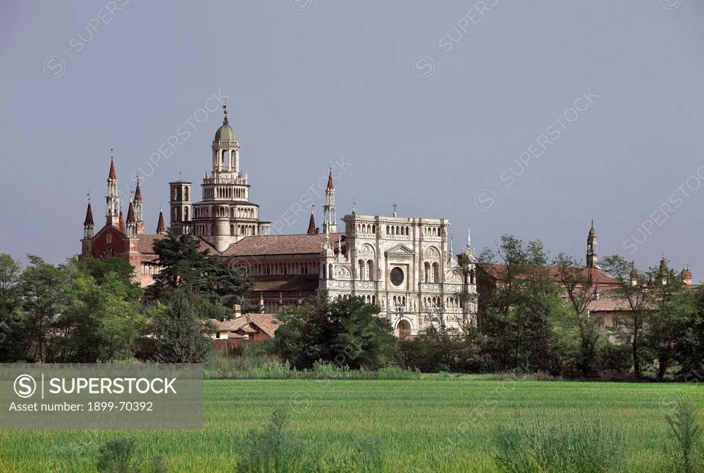 Italy, Lombardy, Pavia, Carthusian monastery. Whole artwork view. View of the monastery front, in a country lansdcape. The towers and pinnacles are also visible.