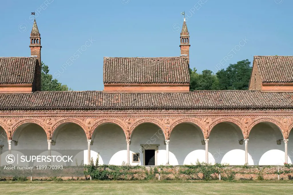 Italy, Lombardy, Pavia, Carthusian monastery. Detail. An arcade of the grand cloister. Upon the columns are the arches with white and pink decorations. The tondos contain images of saints, prophets and angels.          The windows of the monk cells, with the view on the loan, are also visible.
