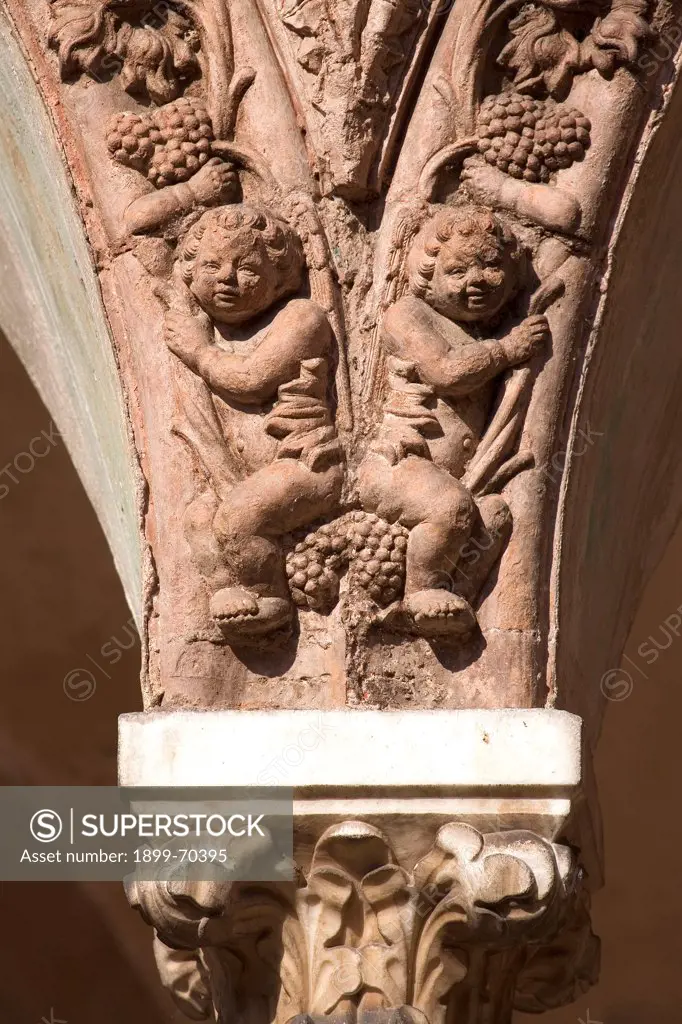 Italy, Lombardy, Pavia, Carthusian monastery. Detail. Terracotta decoration upon a capital of a column in the small cloister's arcade. It depicts two putti hanging on vine stocks.