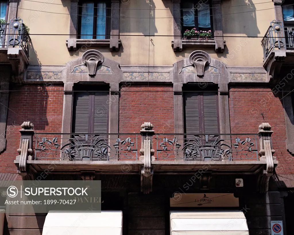 Italy, Lombardy, Milan, Piazzale Baracca. Detail. Frontal view of the balcony of the pharmacy that presents windows and railing made of wrought iron.