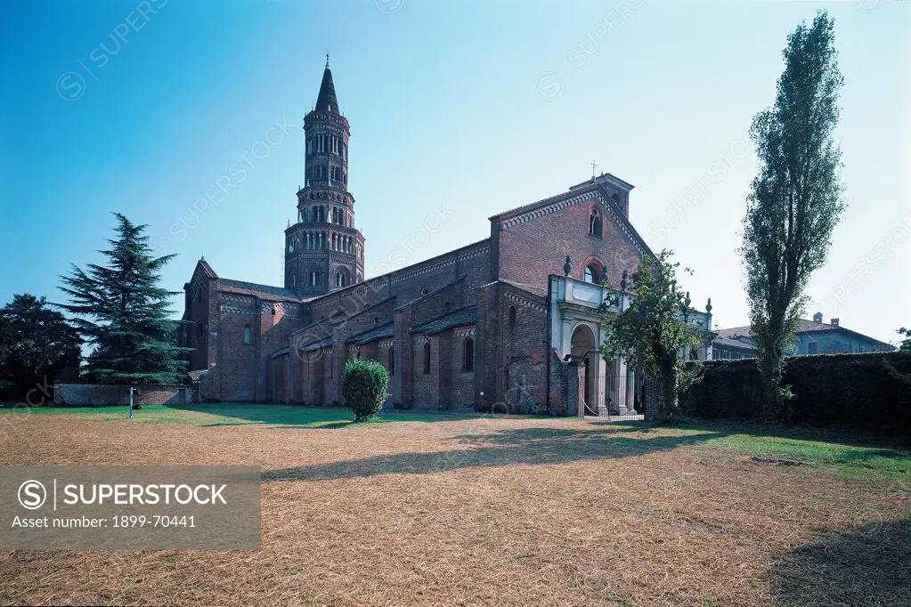 Italy, Lombardy, Milan. Whole artwork view. View of the Cistercian abbey that presents an octagonal bell tower, two-light windows, Lombard bands, buttresses. Foreshortening of the facade with the portico.