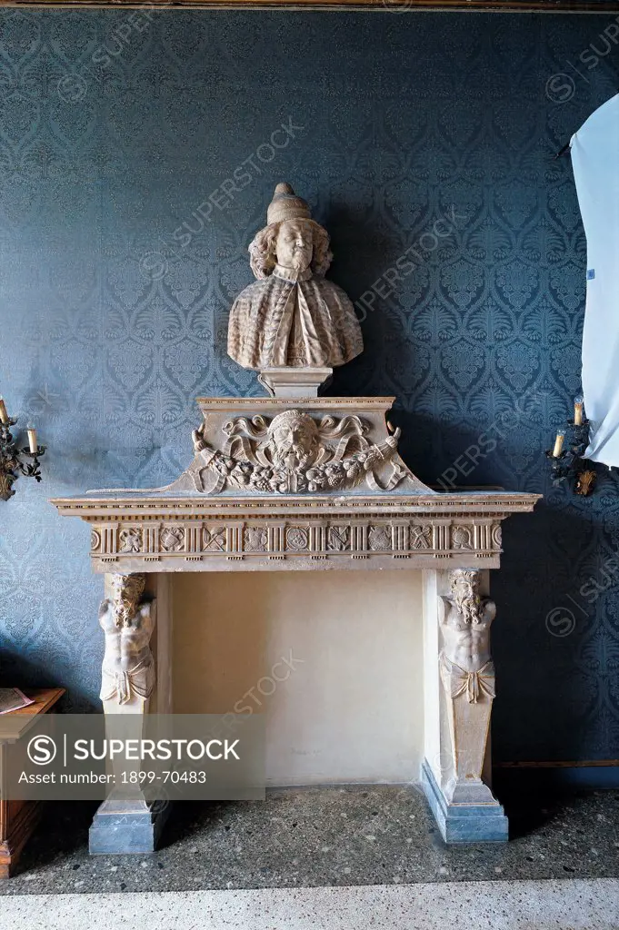 Italy, Veneto, Venice (Venice), Palazzo Corner Spinelli. Whole artwork view. Front view of the marble fireplace decorated with triglyphes, metopes, hermas depicting male figures, a fruit festoon with a big face and a bust.