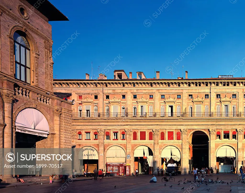 Italy, Emilia-Romagna, Bologna, Palazzo dei Banchi. Detail. Front view of the facade that presents the first order with composite giant pilasters supporting a string course cornice. On the upper floor there are windows with volute tympanums on corbels. In the foreground there is the square Piazza Maggiore.
