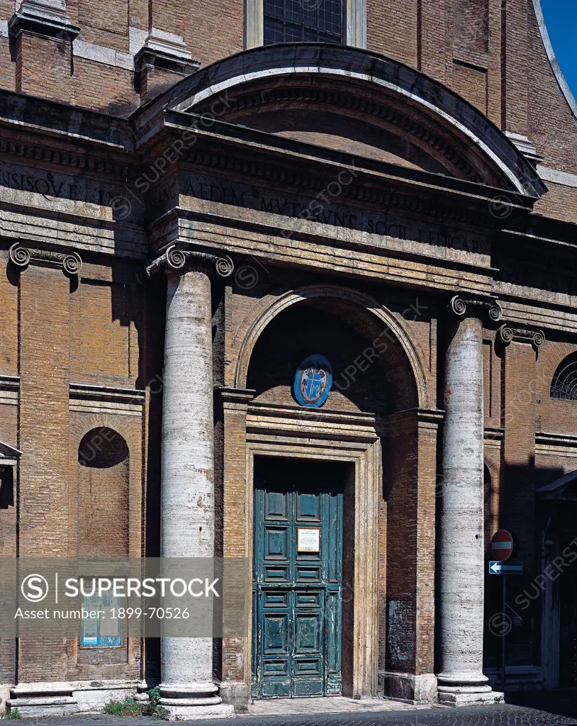 Italy, Lazio, Rome, Church of Santa Maria dell'Orto. Detail. Foreshortened view of the portal framed by two Ionic columns that support an entablature and a curvilinear tympanum.