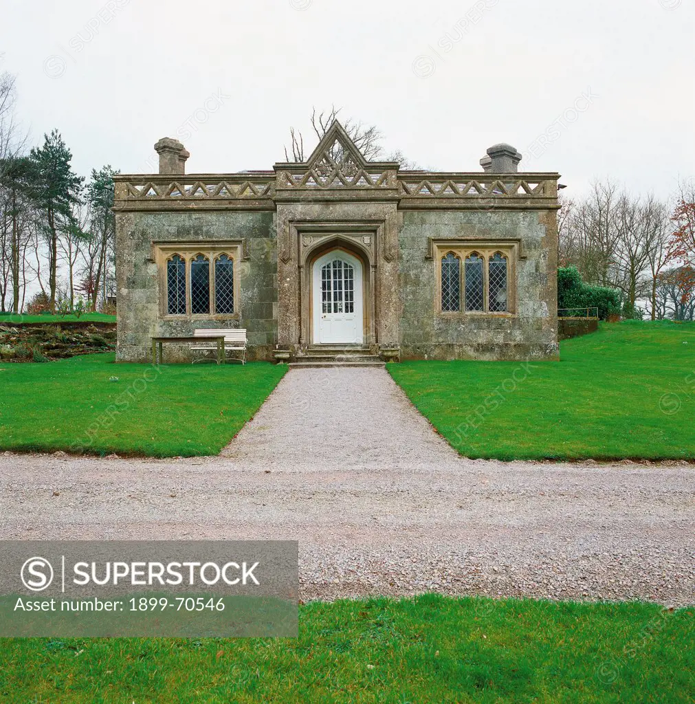 United Kingdom, Stourhead (Wiltshire). Detail. In the park near two paths, front view of a building with balustrade, three-light windows and parapet.
