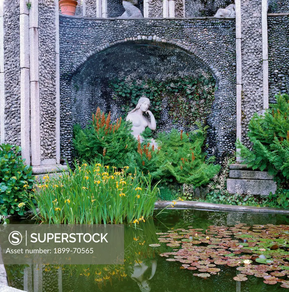 Italy, Lombardy, Isola Bella, Borromeo Gardens. Diana courtyard. Detail. Frontal view of a fountain adorned with a statue of the goddess. Behind her a niche made of granite and tuff.
