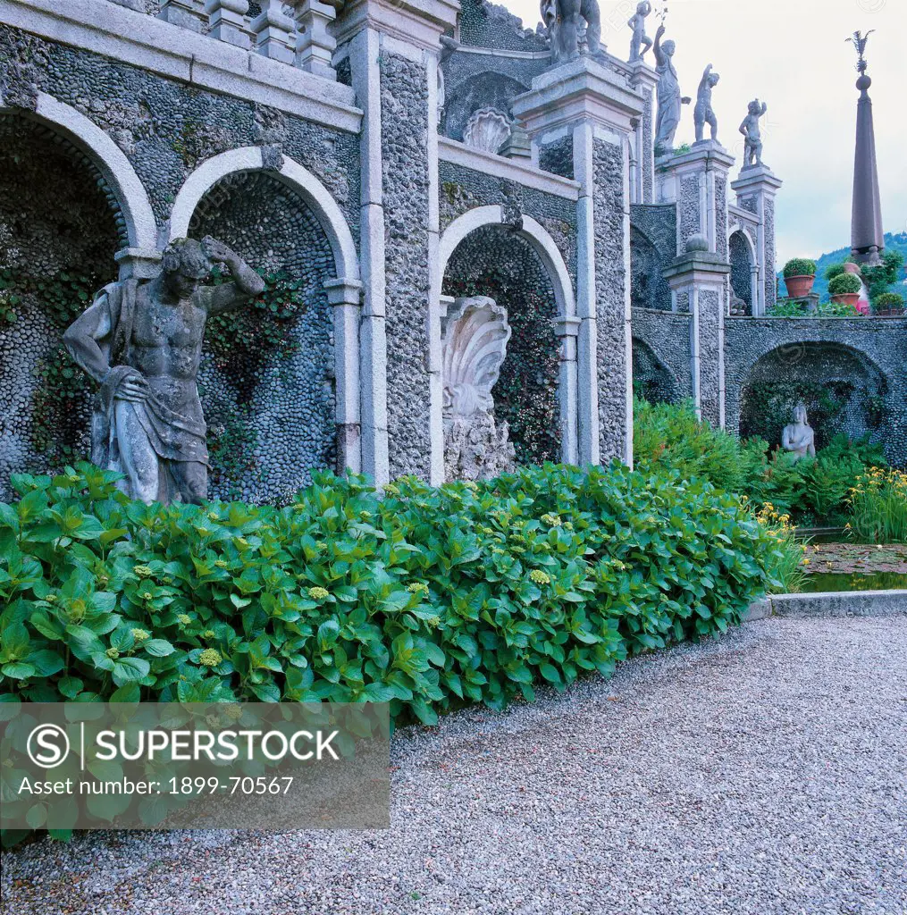 Italy, Lombardy, Isola Bella, Borromeo Gardens. Detail. Foreshortening view from the parterre of the first level of the central exedra. The architectural structure has a rocaille decoration and is adorned with statues and obelisks. On the background Diana fountain.