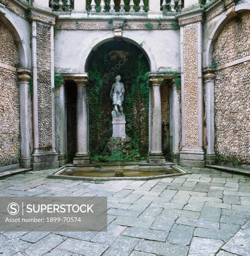Italy, Lombardy, Isola Bella, Borromeo Gardens. Detail. A fountain with a sculpture positioned under a Serliana (Palladian arch).