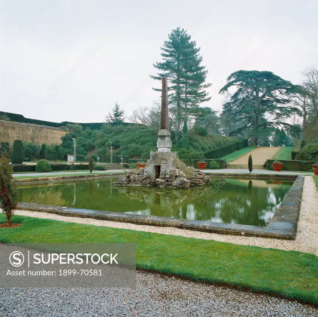 United Kingdom, Oxfordshire, Woodstock, Blenheim Palace. Detail. The pond with a small cave surmounted by an obelisk.
