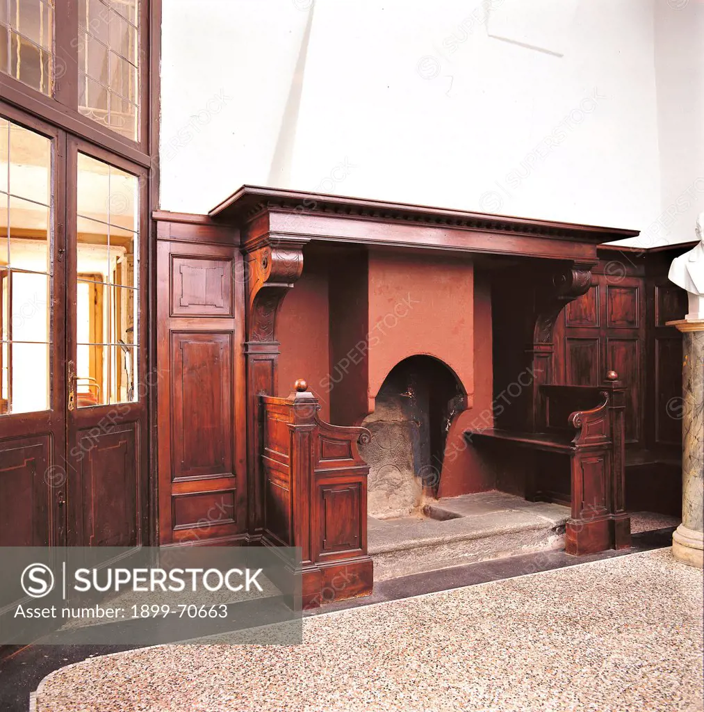 Italy, Lombardy, Lecco, Villa Manzoni, Kitchen. Detail. The fireplace and two sittings made of wood.