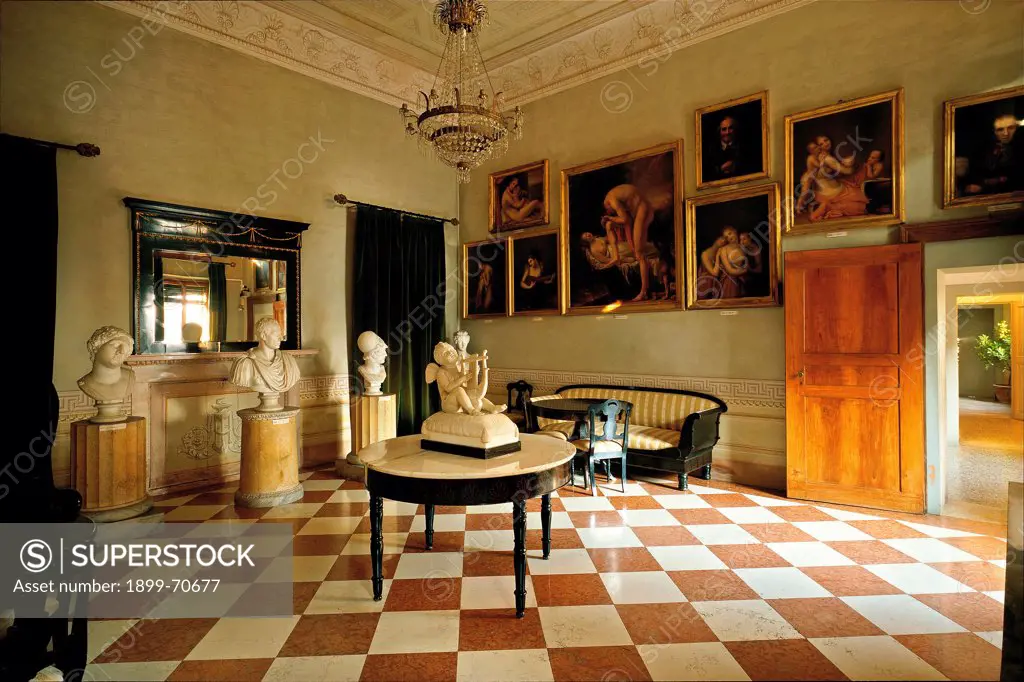 Italy, Veneto, Possagno. Canova's Plaster Cast Gallery and Canova's home. Whole artwork view. Small dining-room situated on the ground floor. On the wall some Canova's paintings and some Canova's sculptures on pedestals and on a table placed in the centre of the room.
