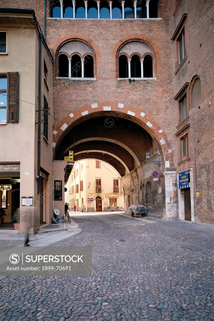 Italy, Lombardy, Mantua, Broletto Square. Whole artwork view. The arch of the Arengario surmounted by two three-light windows.