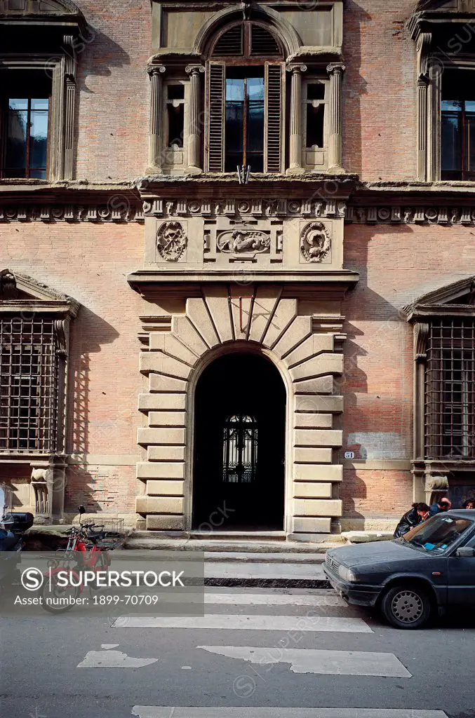 Italy, Tuscany, Florence, Via de' Servi. Detail. A building's entrance covered with ashlar-work. The portal is surmounted by a frieze with heraldic decorations and a window flanked by four columns.