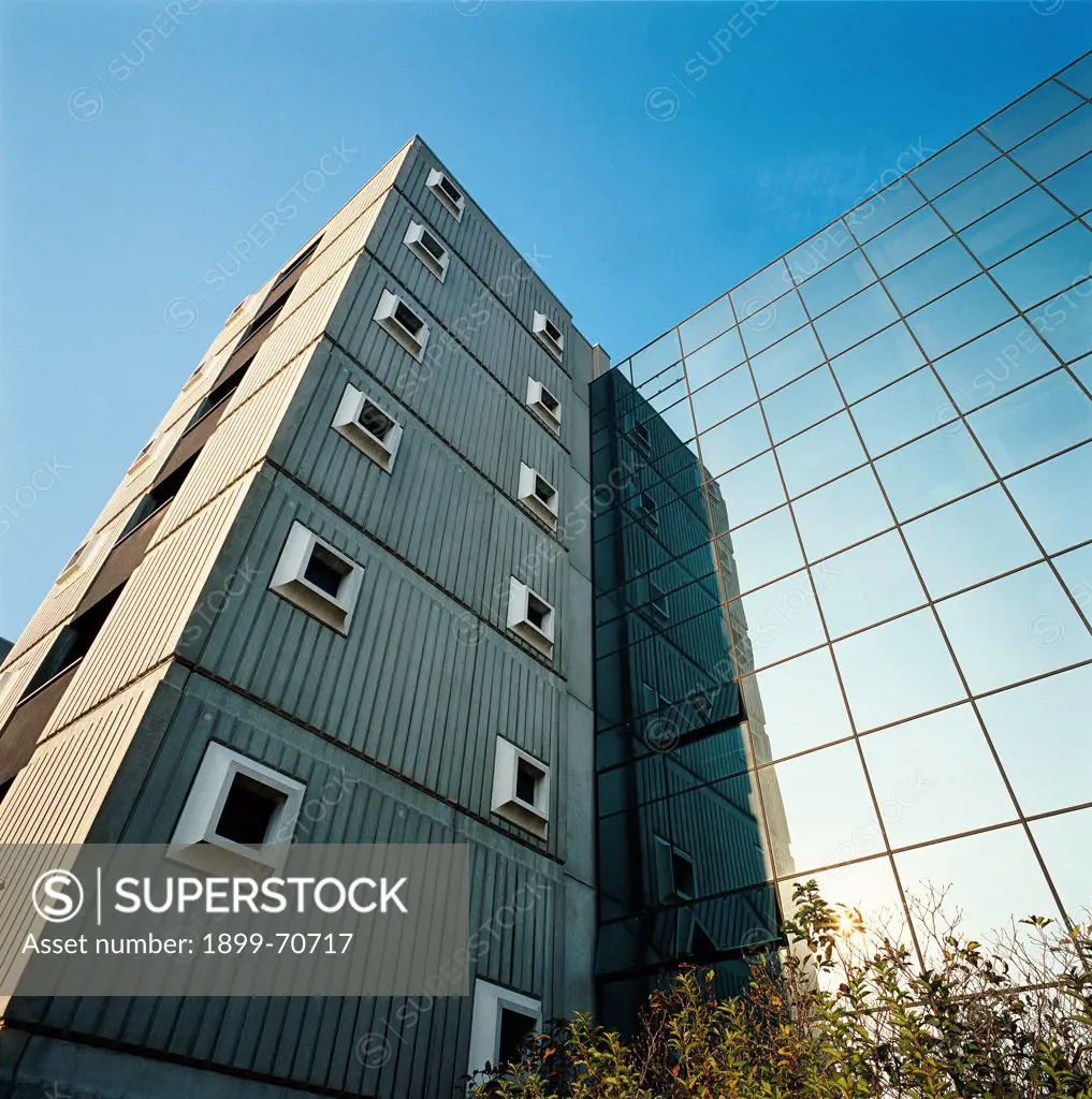 Italy, Lombardy, Milan, Milanofiori. Detail. The external cover of the the stair units livened by vertical flutings and by square-shaped windows. On the right a detail of a glazed facade.