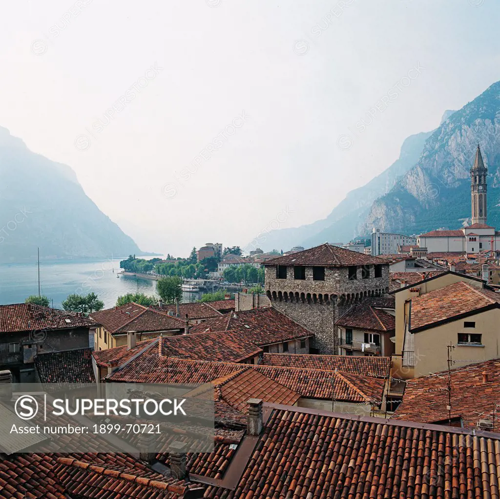 Italy, Lombardy, Lecco. Whole artwork view. View of the crowning of the Visconti Tower. In the background the Como Lake.