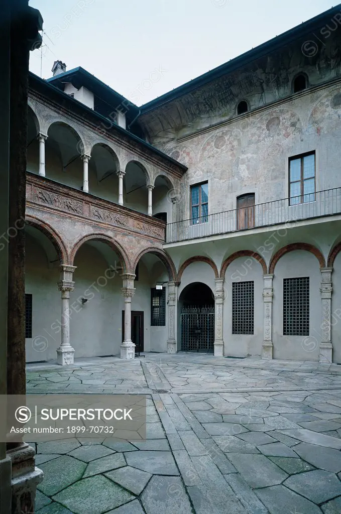 Italy, Lombardy, Cremona, Fodri Palace. Whole artwork view. The inner courtyard of the Fodri Palace which overlooks a double order of loggias decorated with terracotta frames and tiles. On the right a wall decorated with mural paintings.