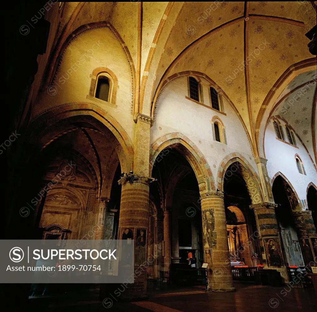 Italy, Lombardy, Lodi, Church of Saint Francis. Detail. The nave with brickwork columns supporting ogival arches and cross-vaults. Walls and columns are decorated with polychrome frescoes.