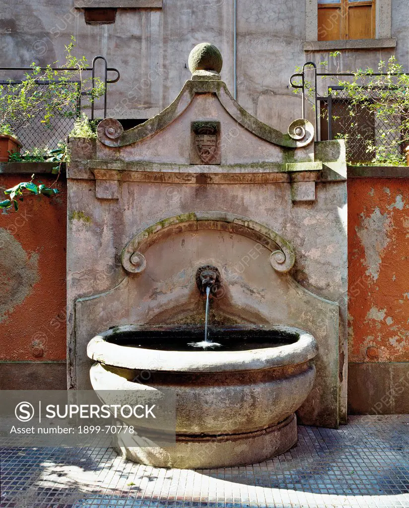 Italy, Lazio, Viterbo, Plebiscito Square. Detail. A stone fountain placed in an inner courtyard of the palace.