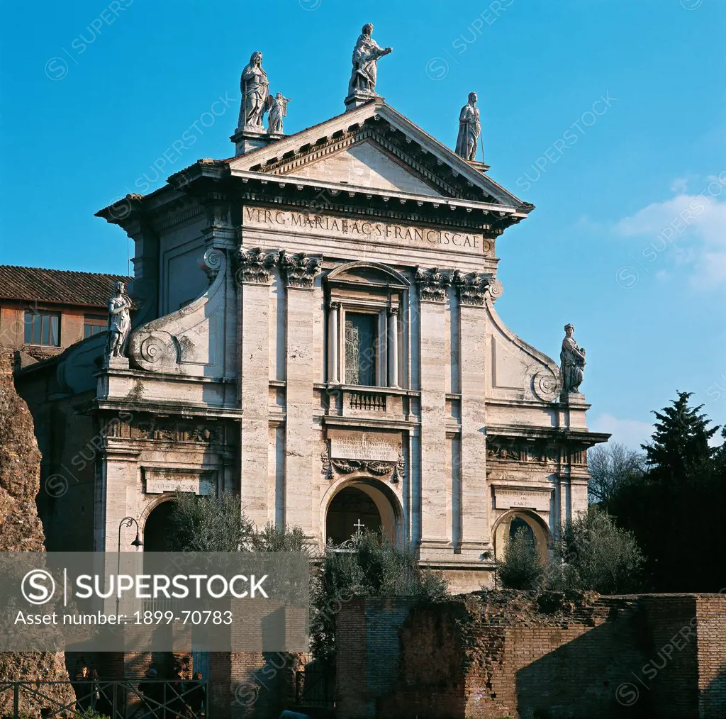 Italy, Lazio, Rome, Church of Saint Francesca Romana. Detail. A foreshortening view of the facade marked out by a triangular pediment surmounted by three statues on the top and by a porch in the basement. The main portal is flanked by pilasters with Corinthian capitals.