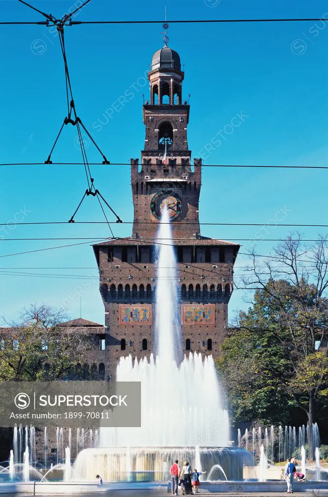 Italy, Lombardy, Milan, Castello Sforzesco. Whole artwork view. The big fortified Filarete's tower of Castello Sforzesco seen in the background of the fountain in the middle of the square.