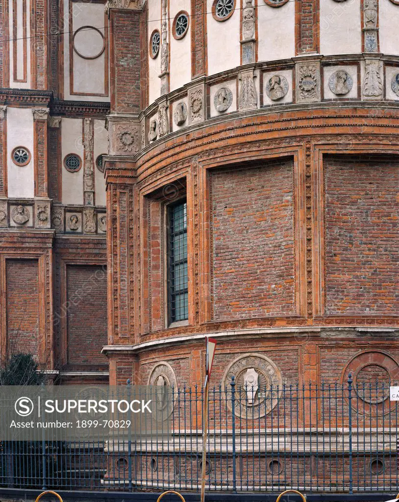 Italy, Lombardy, Milan, Piazza Santa Maria delle Grazie. Detail. Outer part of the church apse: the white panels and round decorations enrich the red brick walls and make them luminous.