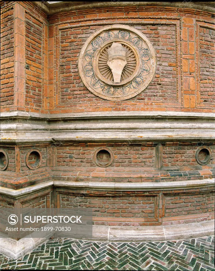 Italy, Lombardy, Milan, Piazza Santa Maria delle Grazie. Detail. Outer part of the church apse: the round decorations enrich the red brick walls and make them luminous.