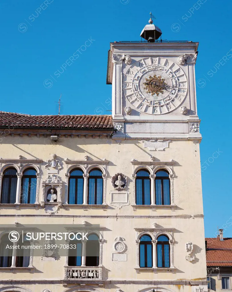 Italy, Veneto, Belluno, Palace of Chancellors (Prefecture). Detail. View of the facade with elegant double lancet windows, bas-reliefs and a clock tower.