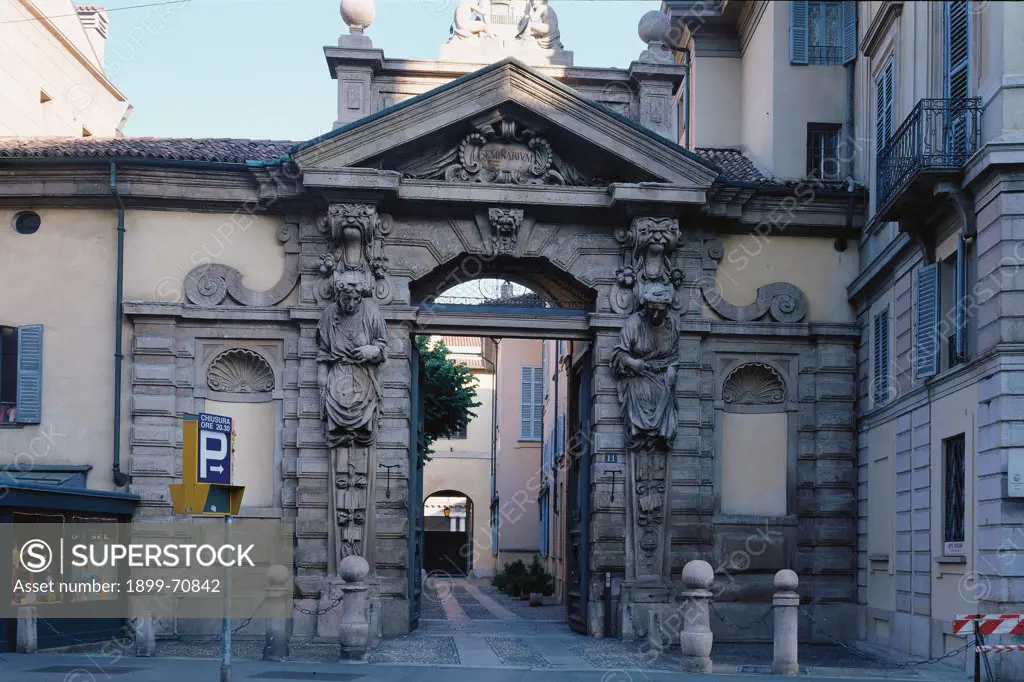 Italy, Lombardy, Milan, Major Seminary. Whole artwork view. Frontal view of the main portal, full of baroque decorations: volutes, niches, broken architraves and rough rustication.