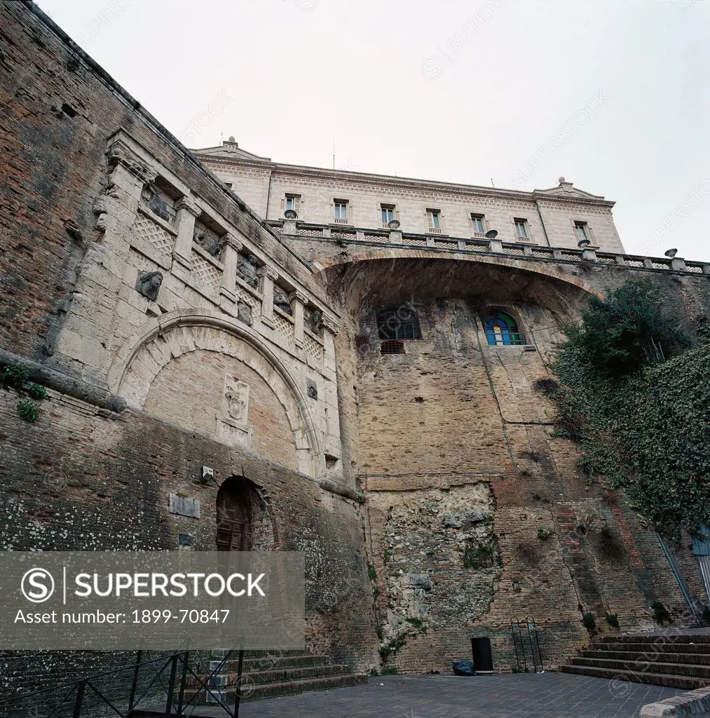 Italy, Umbria, Perugia. Detail. View from a low angle of the strong walls of the Rocca used as a foundation for the nearby houses. On top, the banisters of Piazza Italia and of the Prefecture Palace.