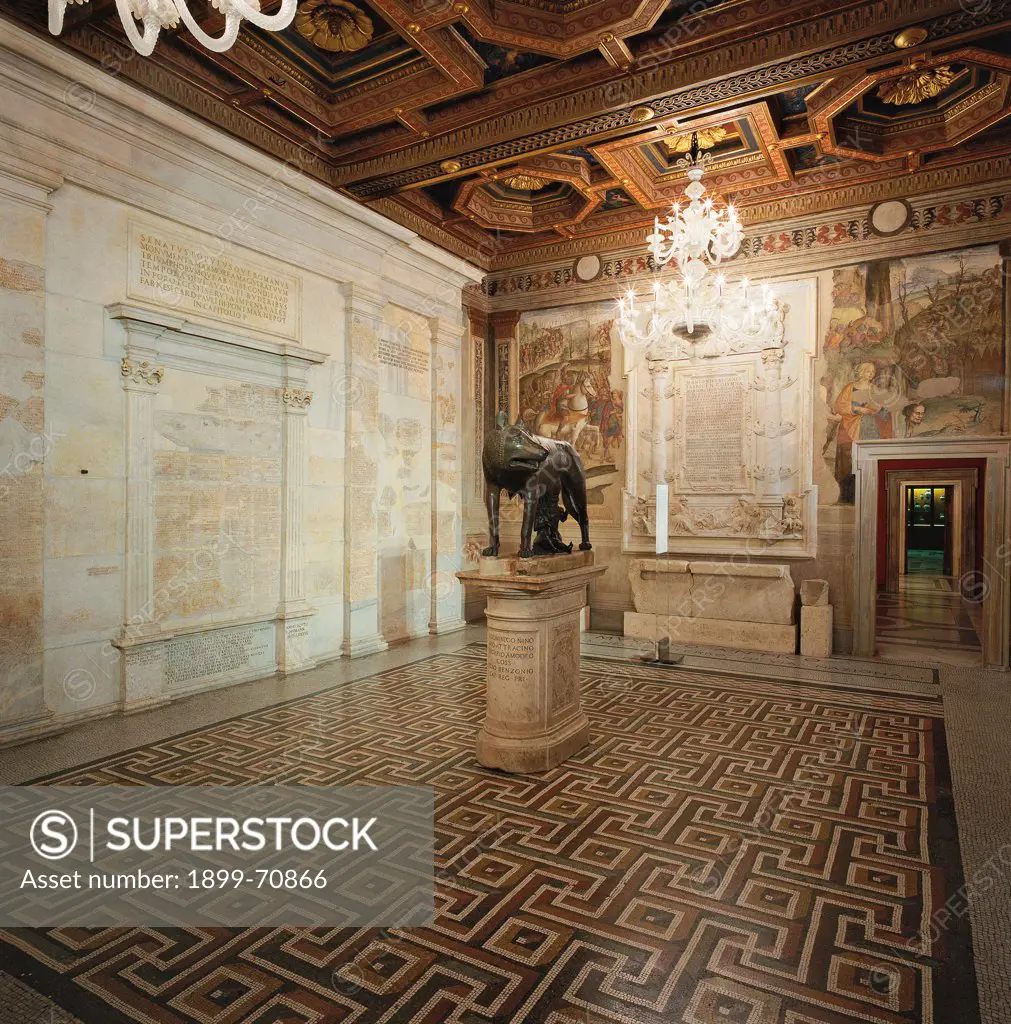 Italy, Rome (Rome), Palace of the Conservators. Detail. View of the Wolf Room (Sala della Lupa), with the wolf bronze statue in the middle. On the walls, fragments of the frescos of Fasti Consulares and Fasti Triumphales. The rich pavement is made with mosaics representing geometrical and colored patterns.