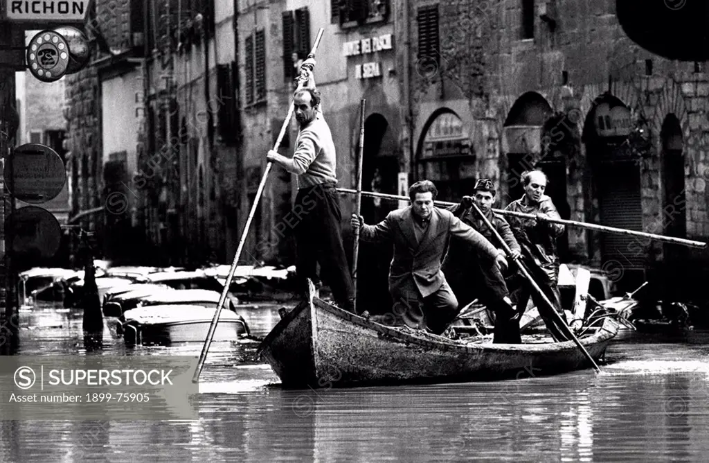 A group of men aboard a boat in the historic center of Florence during the flood of 1966. Italy