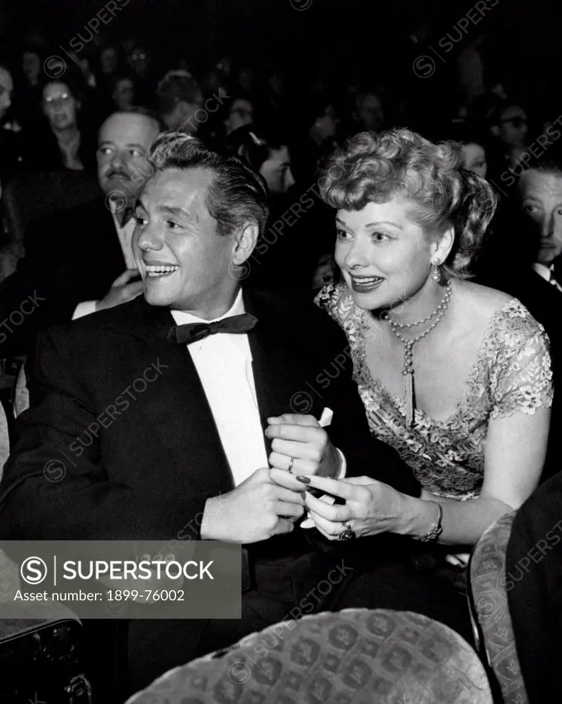 American actress Lucille Ball (Lucille DŽsirŽe Ball) smiling and sitting beside her husband, the Cuban-born American actor Desi Arnaz (Desiderio Alberto Arnaz y de Acha III). 1950s.
