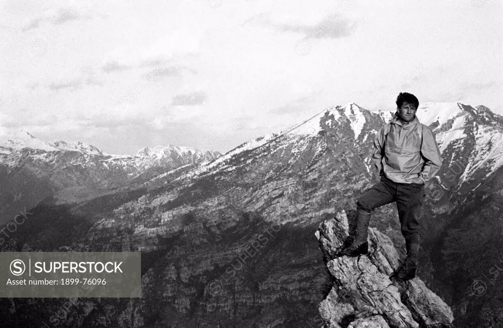 Italian climber and explorer Carlo Mauri sitting on top of a mountain. Italy, 1960s.