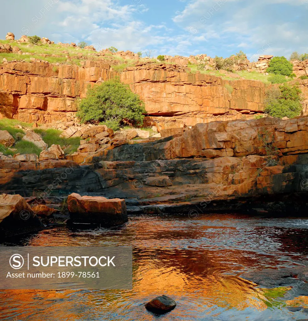Ancient cliffs reflect in wet season water on Cowandyne Creek, King Leopold Ranges, Mornington Wildlife Sanctuary, central Kimberley, Western Australia