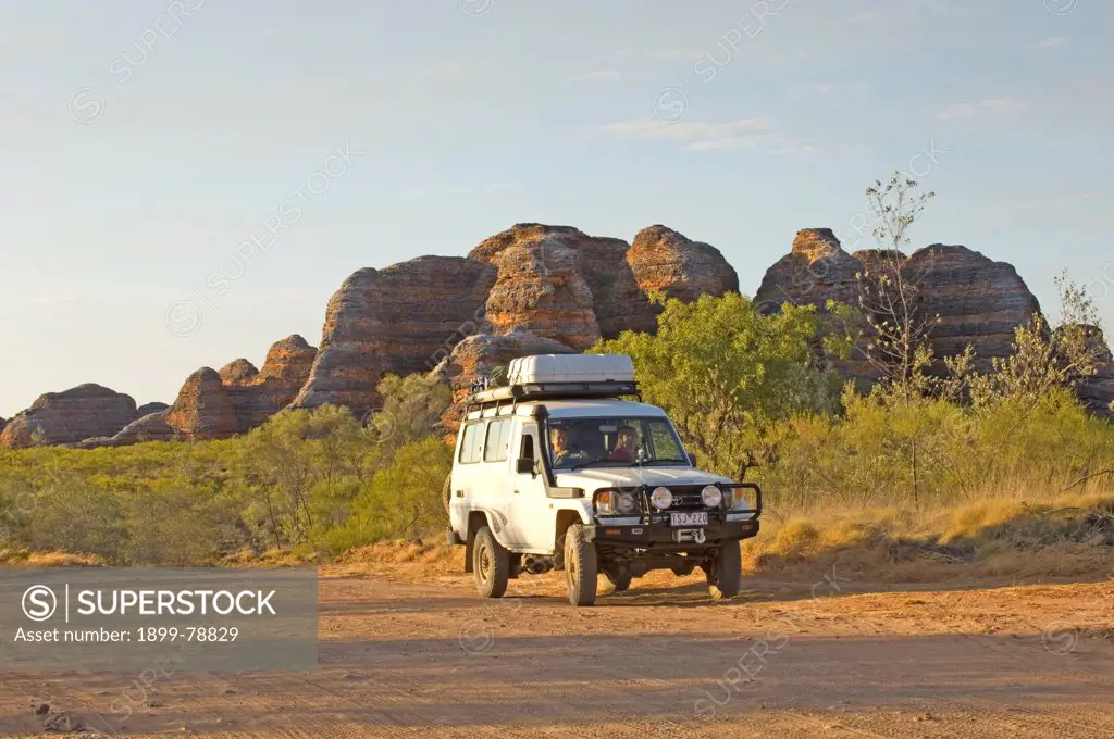 Four-wheel drive vehicle with beehive formations beyond, Purnululu National Park, Kimberley region, Western Australia