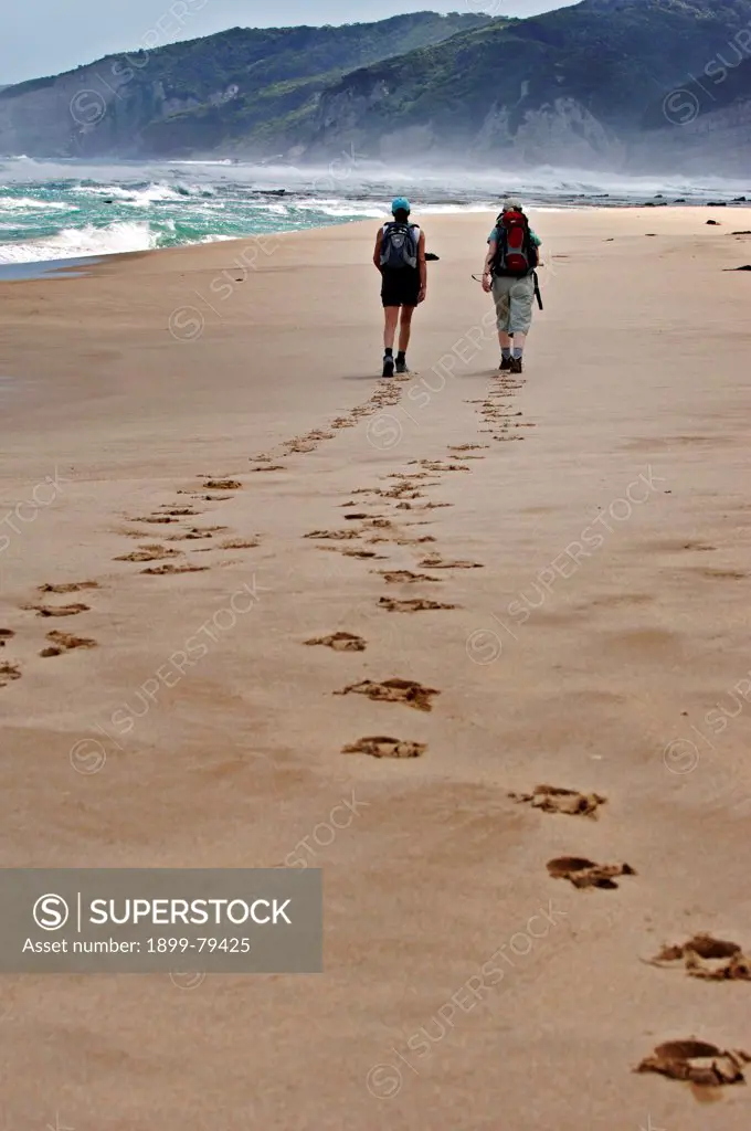 Hikers walking along beach near Apollo Bay, Great Ocean Road, Victoria, Australia