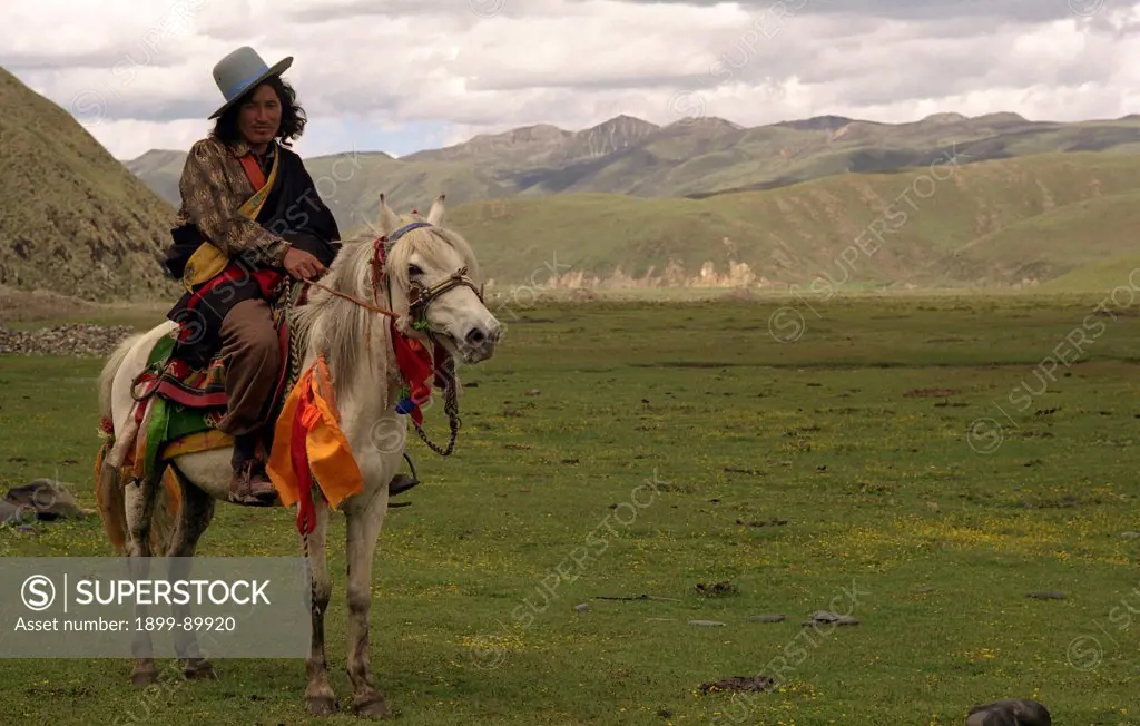 Tibetan horseman posing with his horse on the grasslands, Tagong, Sichuan Province, China, June 2004