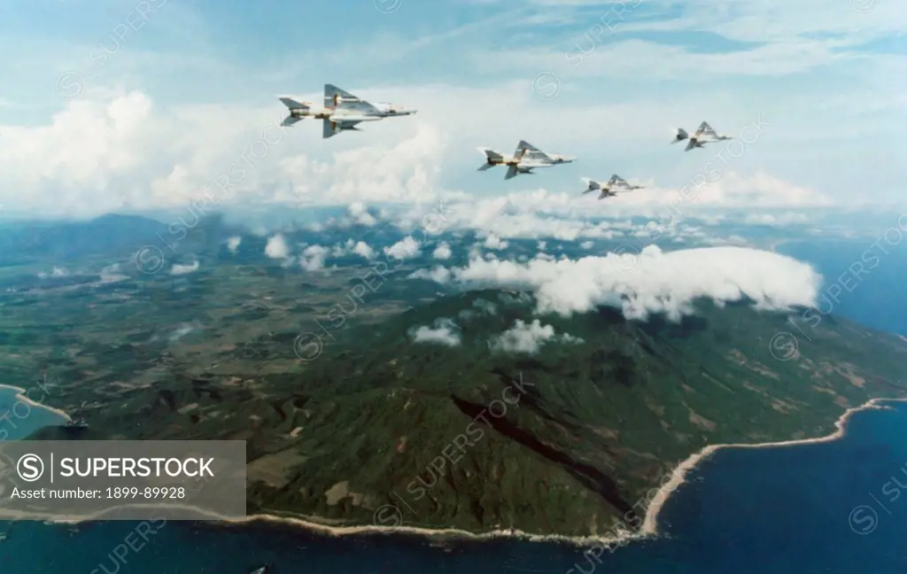 Chinese Navy Chengdu J-7 fighter jets in flight during an exercise over a coastal region. China. 1996.