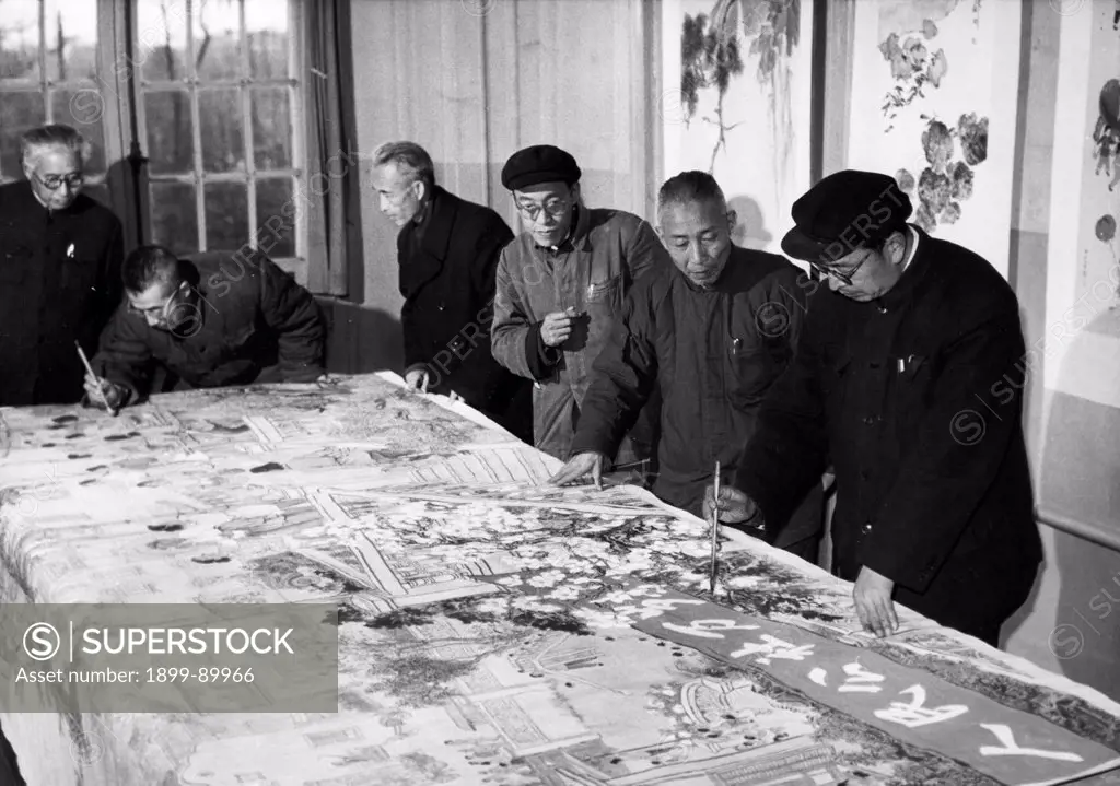 Famous painters of the Shanghai studio Tang Yun (1st from right), Hsieh Chih-kwang (2nd from right) and Cheng Shih-fa (2nd from left) are shown working together on a huge traditional Chinese painting 'Long Live the People's Commune'. 1960.